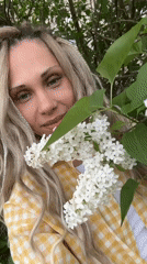 Woman photographed with blooming lilacs in rural Russia