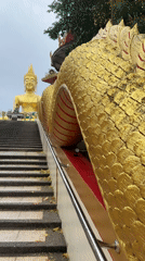 Golden Buddha statue and ornate stairway documented in Pattaya