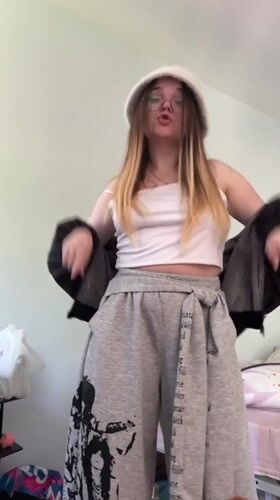 Young woman dances in bedroom wearing white hat in Russia