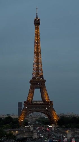Eiffel Tower glows on Bastille Day at dusk