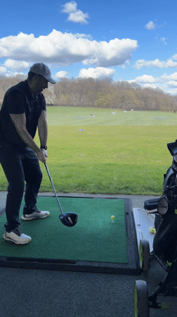Man practices golf swing at Luxembourg driving range