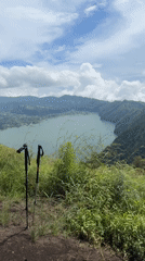 Mountain hiker documents scenic trail with lake views in Kintamani