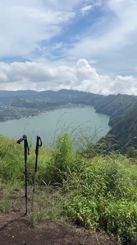 Mountain hiker documents scenic trail with lake views in Kintamani