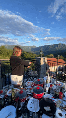 Woman sabers champagne bottle on mountain balcony in Montenegro