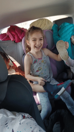 Mother records video with laughing children in car