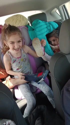 Mother records video with laughing children in car