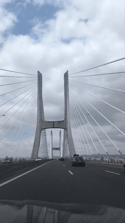 Driving toward a massive cable-stayed bridge in Lisbon
