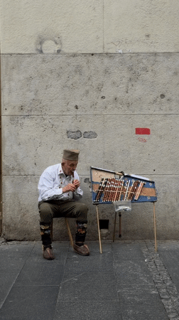 Traditional musician performs on Belgrade street near public fountain