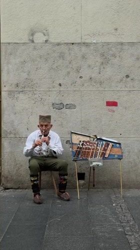 Traditional musician performs on Belgrade street near public fountain