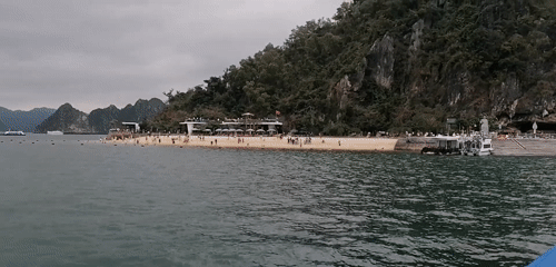 Tourist boats navigate Ha Long Bay under cloudy skies
