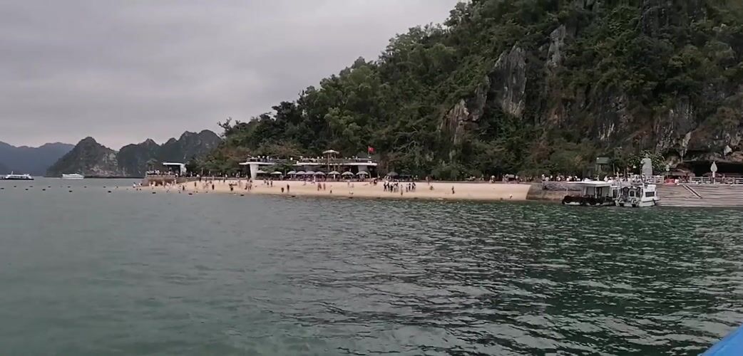 Tourist boats navigate Ha Long Bay under cloudy skies