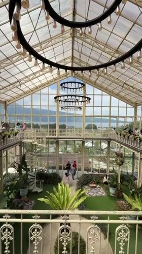 Inside a glass greenhouse café and gardens in Baturiti