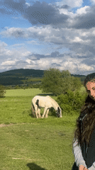 Woman observed in pastoral field with grazing animals in Bulgaria