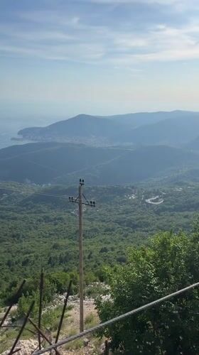 Paraglider soars over scenic Montenegro coastline near Boreti