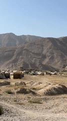 Tent encampment stretches across arid mountain terrain near Mastung