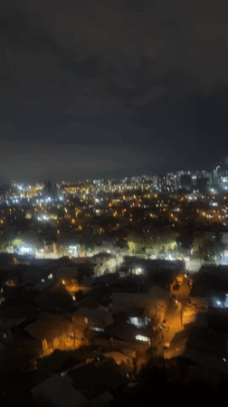 Aerial night footage captures Tbilisi cityscape panorama