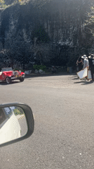 Red vintage convertible parked near cliff in Kuta Selatan