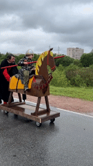 Man pushes wooden horse toy with child in Vsevolozhsk