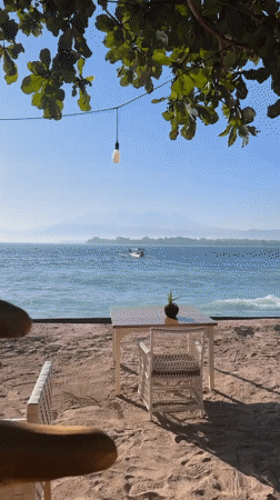 Lazy morning at a tropical Indonesian beach with boats offshore