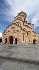 Visitor documents cathedral grounds with elaborate gardens and architecture