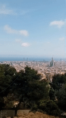 Visitors document sunny afternoon views from Barcelona hilltop garden