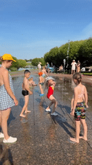 Kids cool off at a Minsk splash pad on a summer afternoon