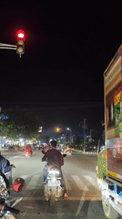 Evening traffic observed at Lhokseumawe intersection with motorbikes, truck