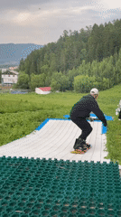 Summer dry-slope snowboarding session at a Divnogorsk hillside park