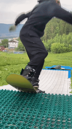 Summer dry-slope snowboarding session at a Divnogorsk hillside park