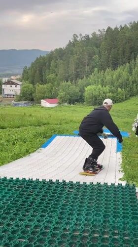 Summer dry-slope snowboarding session at a Divnogorsk hillside park