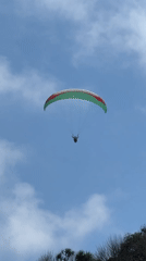 Paragliders over Kuta Selatan beach on a sunny Bali morning