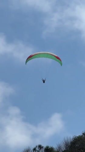Paragliders over Kuta Selatan beach on a sunny Bali morning