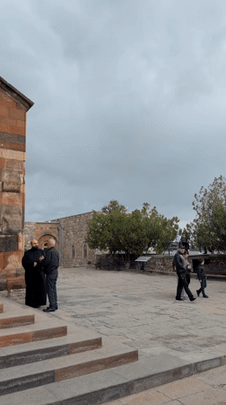Monk meets visitor at Armenian monastery on cloudy morning