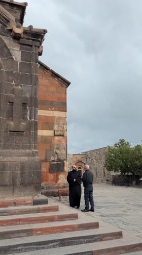 Monk meets visitor at Armenian monastery on cloudy morning