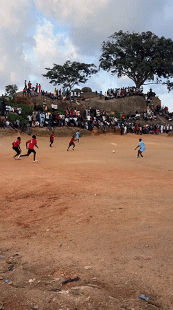 Community soccer and local gathering on the rocky fields of Jos