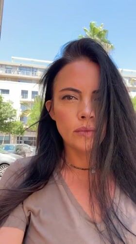 Back-to-back selfies on a Tel Aviv street, midday.