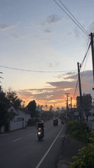 Evening traffic flows through Goviyapana during colorful sunset