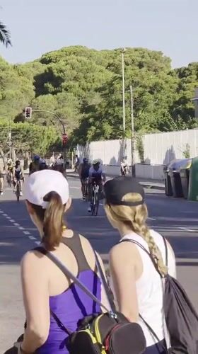 Triathlon cyclists race through sunny Grao streets