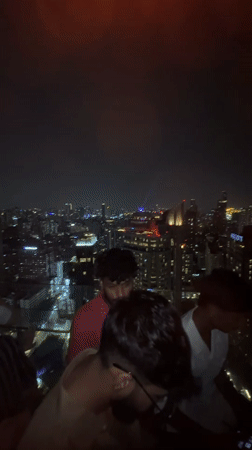 Rooftop bar buzzes with activity overlooking Bangkok skyline