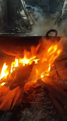 Large pot over open fire, outdoor cooking at night in Lhokseumawe