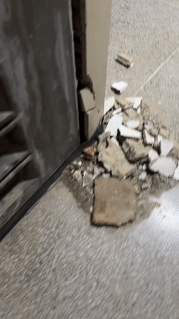 Cracked walls and exposed brickwork inside a Caracas building