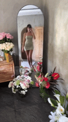 Woman takes mirror selfies in green dress at Kuta resort