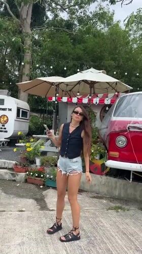 Woman explores quiet Thai fishing village on overcast morning