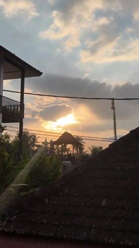 Golden sunset settles over Ubud rooftops and thatched village structures