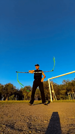 Green ribbon pole performance in an outdoor space, Qarağandı