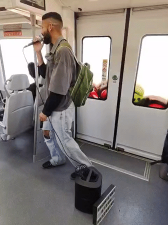 Man performs with microphone on train