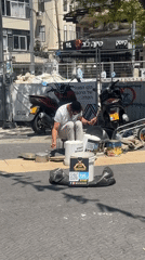 Street drummer performs with buckets in Tel Aviv marketplace