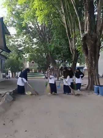 Students conduct nighttime cleanup at Lhokseumawe school courtyard