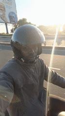 Motorcyclist rides through Dar es Salaam during bright morning hours