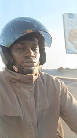Motorcyclist rides through Dar es Salaam during bright morning hours